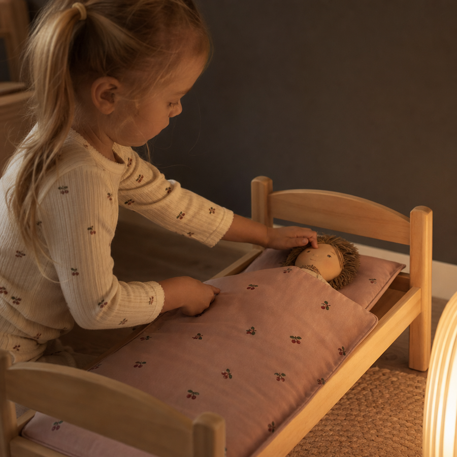Barn leger med Konges Sløjd dukkesengetøj cherry blush